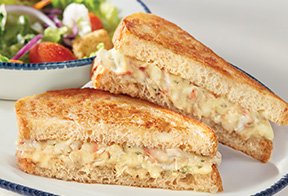  NEW! Crab Melt Sandwich, halved and stacked on a plate. 