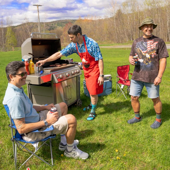 Three dads round the barbecue wearing questionable clothing choices, but awesome Darn Tough socks