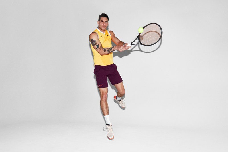 GQ Staffer Mick Rouse jumping and swinging a tennis racket