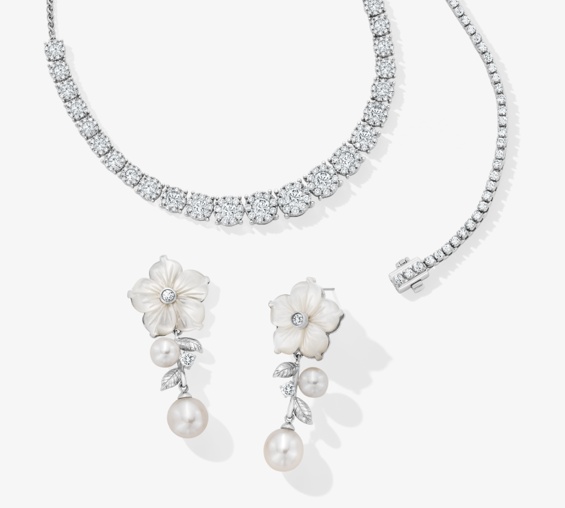 Image of a beautiful diamond necklace, and floral earrings. 