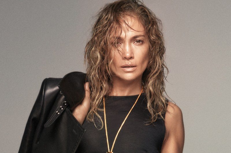 jennifer lopez holds a coat over her shoulder