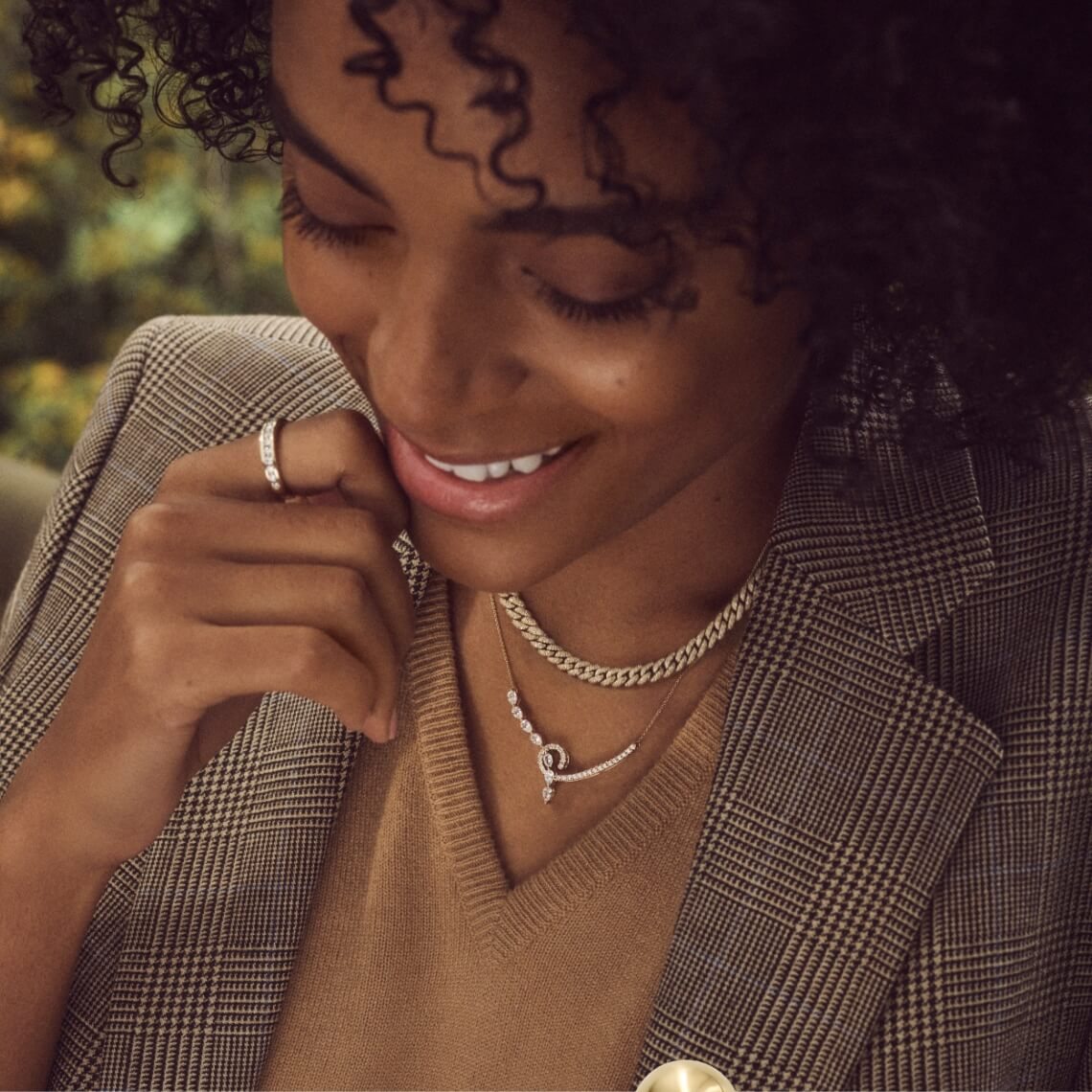 Image of smiling woman wearing multiple pieces of jewelry
