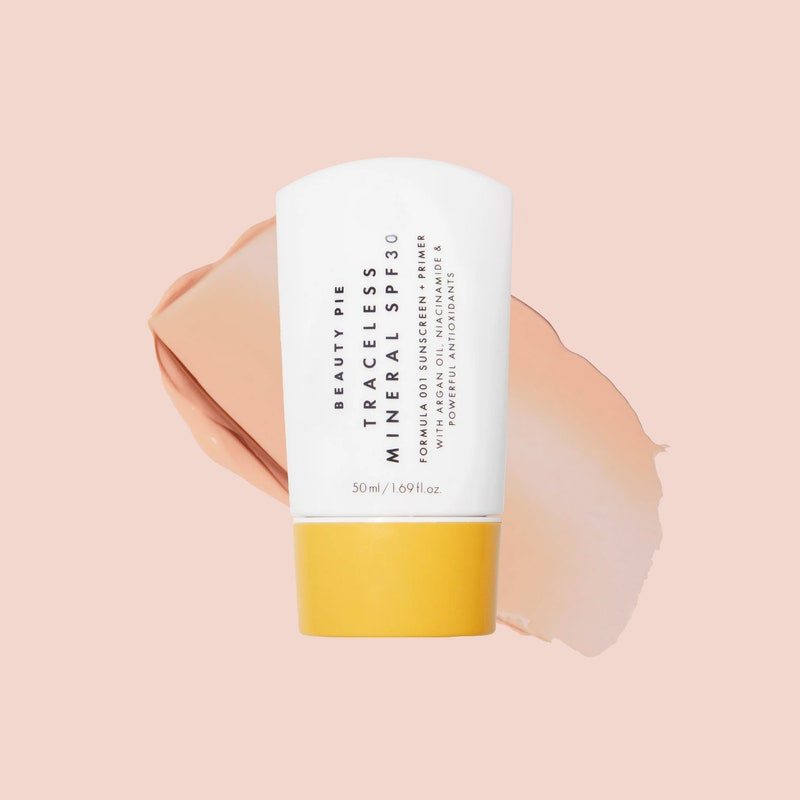 A white tube of the Beauty Pie Traceless SPF 30 Sunscreen + Primer on a light pink background