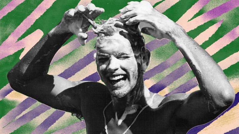 A black and white photo of a man washing his hair, with hand colored elements