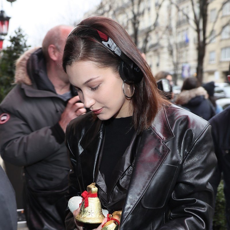 Bella Hadid pairs a headphone headband with silver hoops.