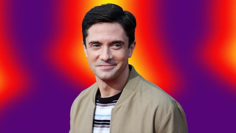 Actor Topher Grace smiling on an abstract colorful bacgkground