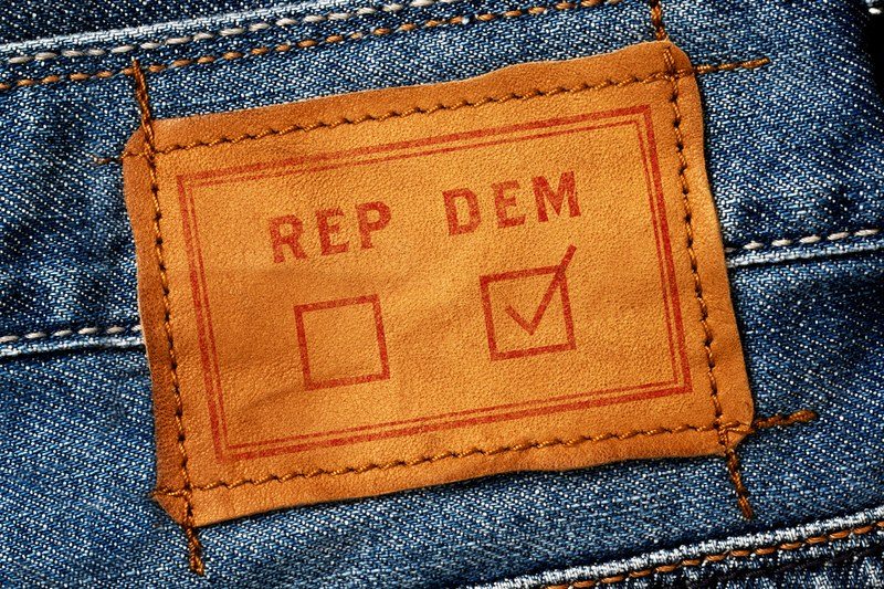 Close-up of a leather tag on a pair of jeans, with DEM and REP voting options. The DEM box is checked