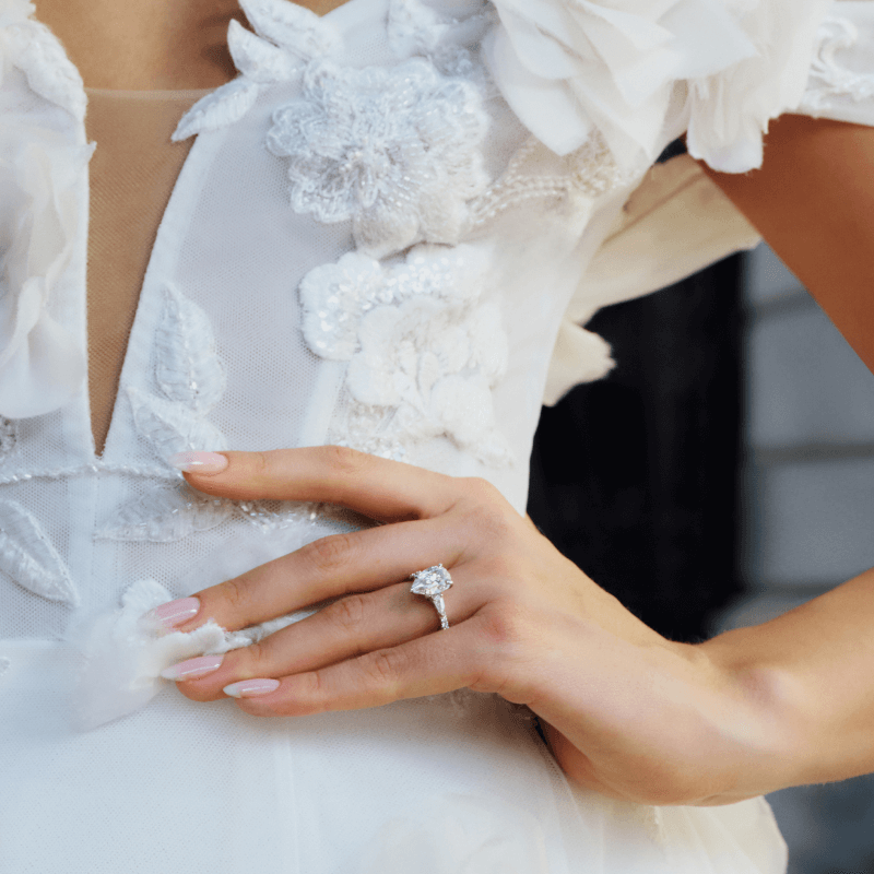 A bride poses, prominetly showcasing her new stunning Diamomd Ring.