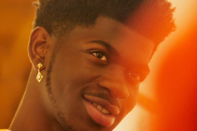 Lil Nas having his photo taken in a orange filter.