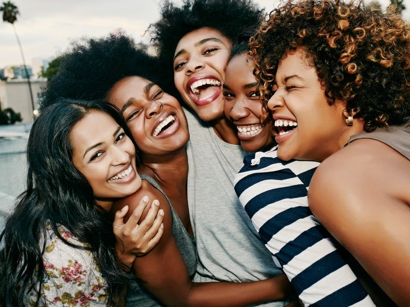 Women laughing together on urban rooftop