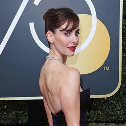 Alison Brie pairs a red lip with side-swept bangs.