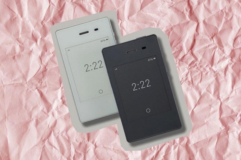 A light phone on a red paper background