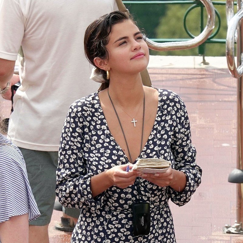 Selena Gomez pairs a scrunchied low ponytail with gold hoops.