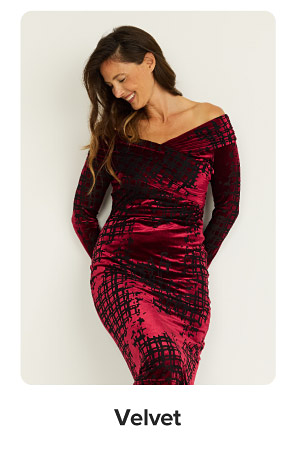  Image of a woman wearing a red velvet dress. Velvet.