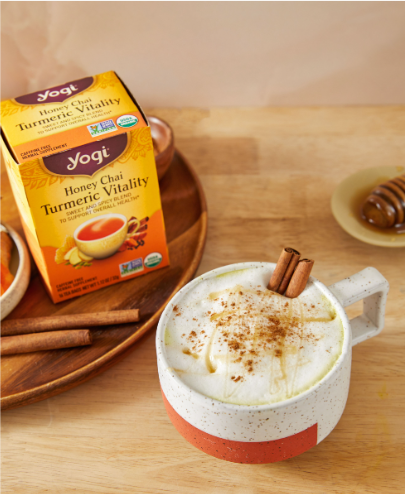 Honey Golden Milk Latte sits on a counter next to a carton of Honey Chai Turmeric Vitality