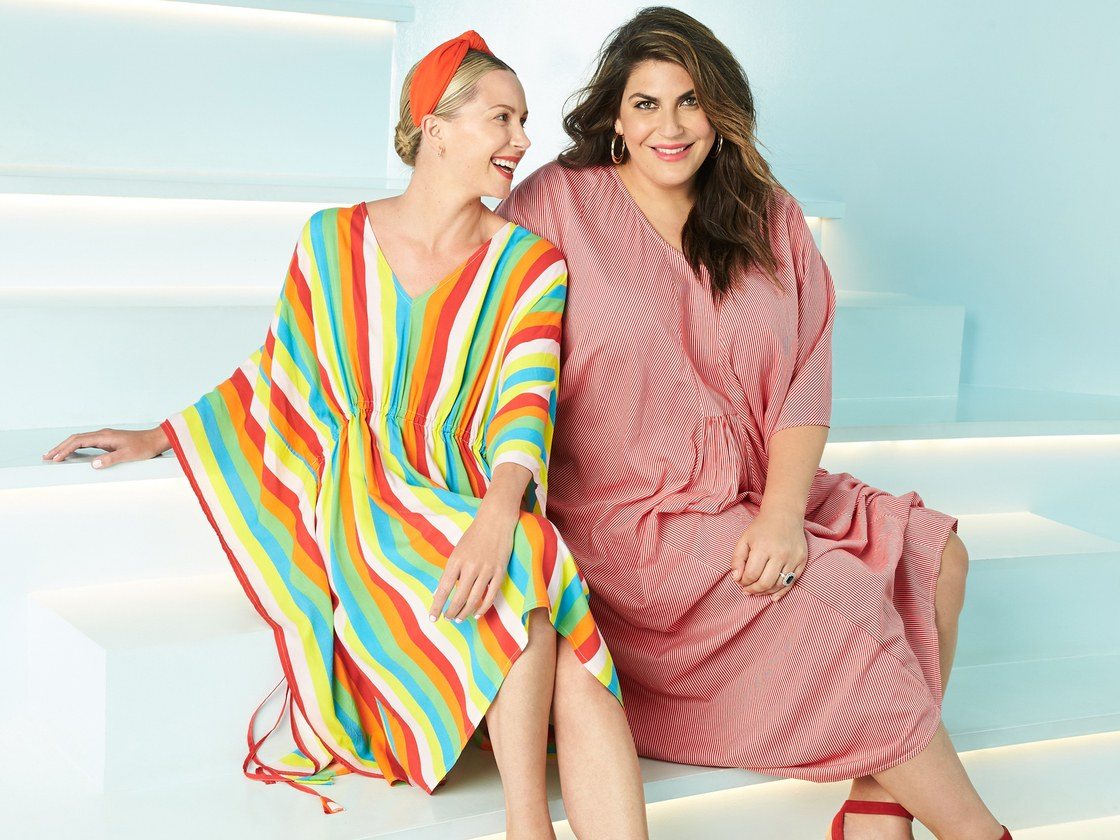 two woman sitting on steps wearing caftans