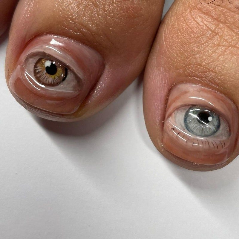 two big toes with extremely-realistic eyes drawn on each nail 