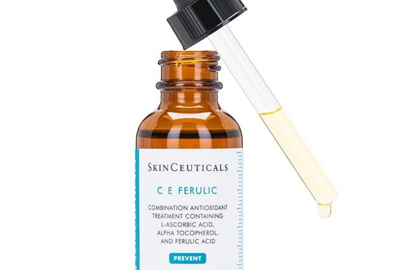 An open bottle of SkinCeuticals C E Ferulic with a dropper full of product on a white background