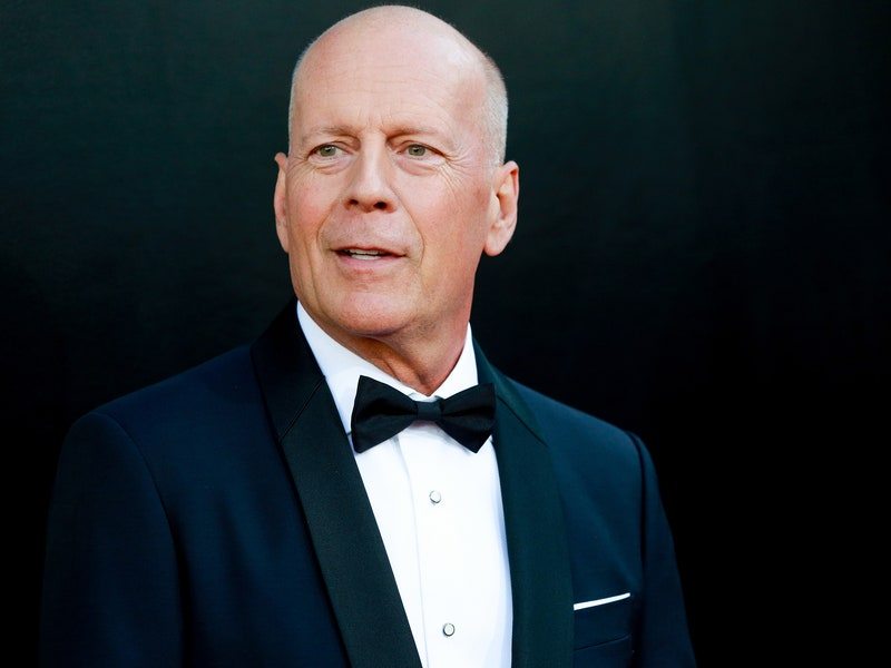 Image may contain: Bruce Willis, Clothing, Apparel, Tie, Accessories, Accessory, Suit, Coat, Overcoat, Tuxedo, and Human