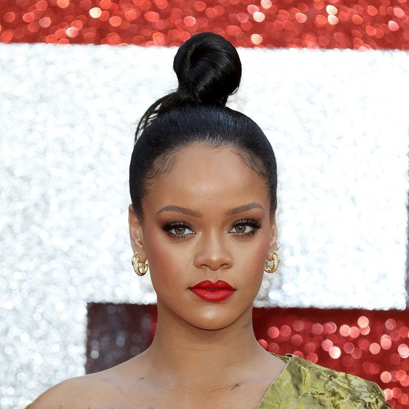 Rihanna pairs a sleek updo with a red lip.