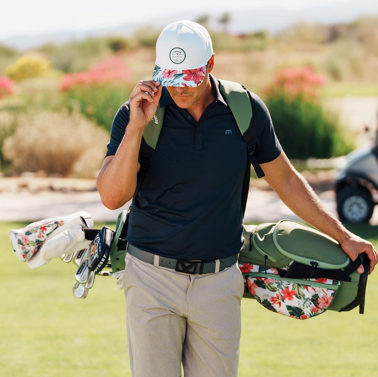 Golfer wearing Aloha Collection hat and holding Aloha Collection golf bag