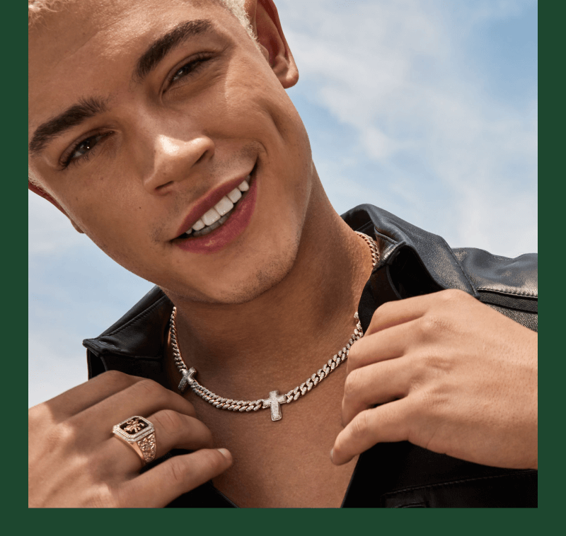 A smiling man poses, adorned with a stunning Necklace and a Ring.