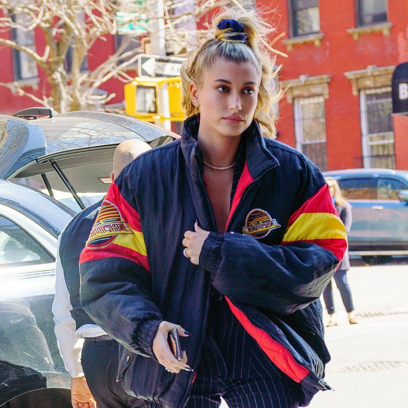 Hailey Baldwin finishes a half-up hairstyle with a scrunchie.