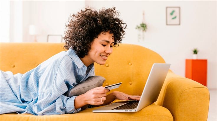 women entering card details in laptop