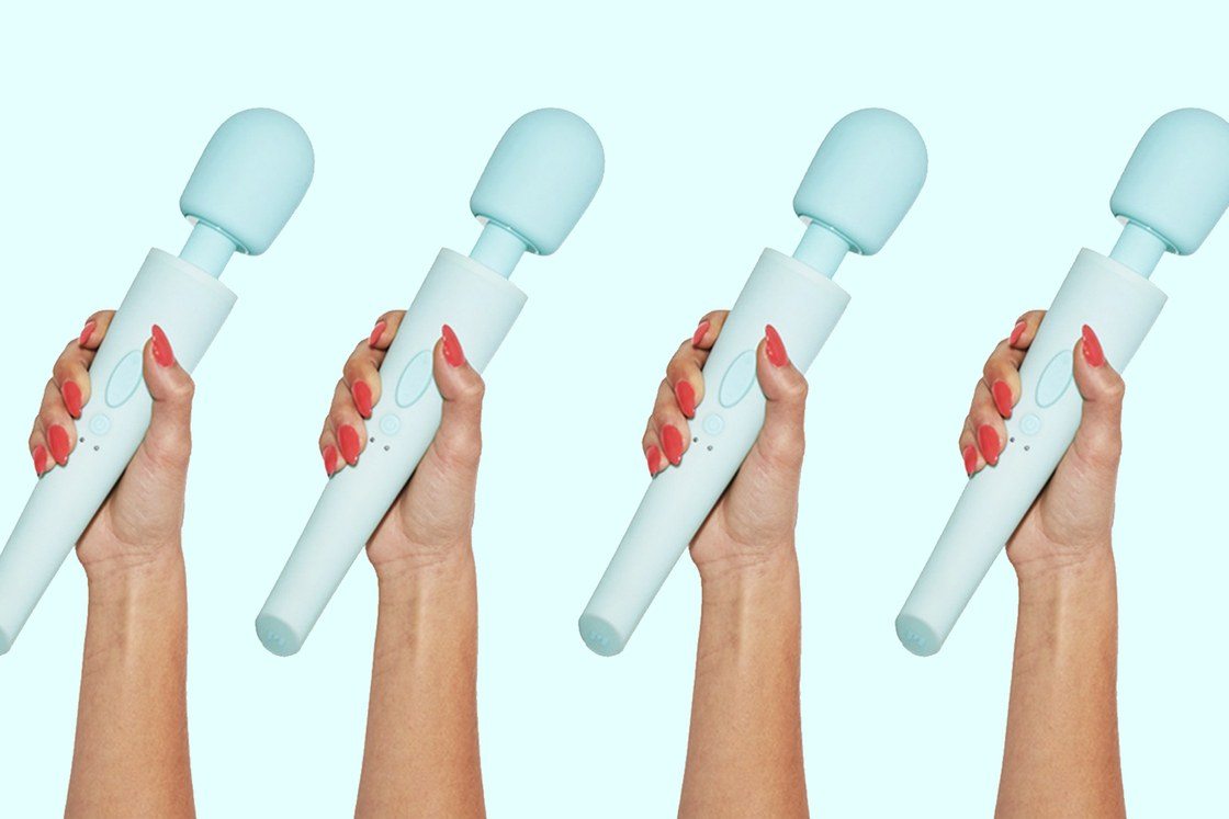 Hand holding the Ollie wand vibrator on a blue background.