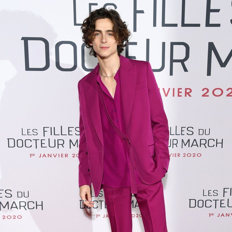 Timothée Chalamet wearing a pink suit on a red carpet