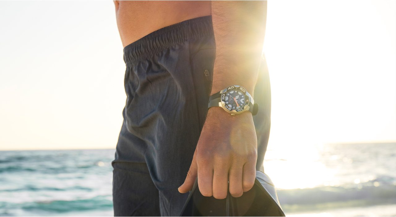 Man at the beach, wears a black dial, black strap Promaster Dive watch