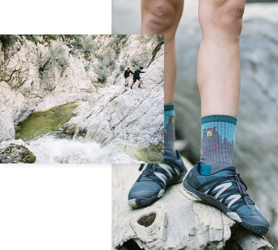 Two friends climbing around a rocky river, and one has grrrreat socks featuring a bear. The bear has fierce pink claws.