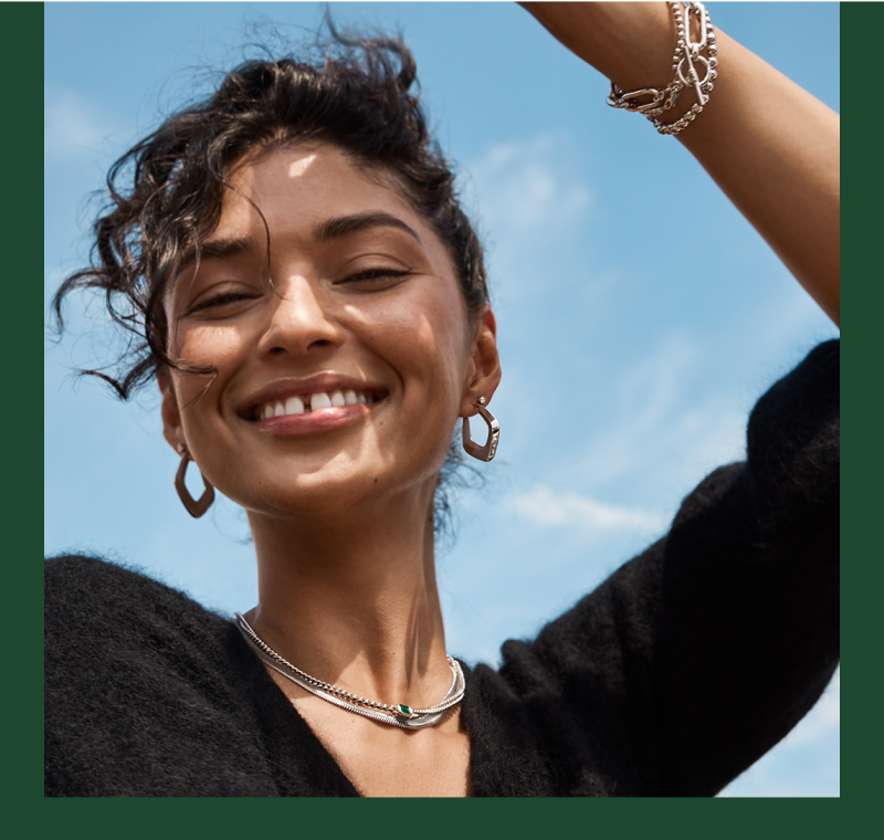 A woman dressed in a black top adorned with elegant silver jewelry, exuding sophistication and style.