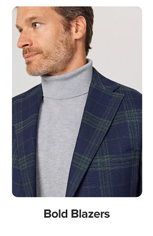 Image of a man wearing a grey turtleneck and plaid blazer. Bold blazers.