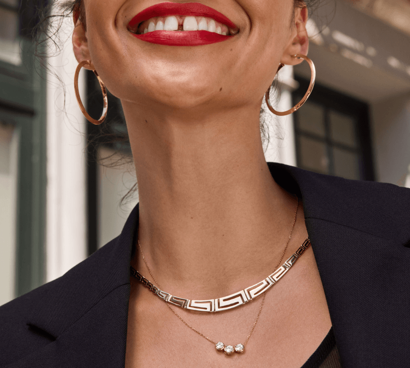 A smiling woman poses, showcasing her new beautiful Diamond Jewelry - Necklaces and Earrings.