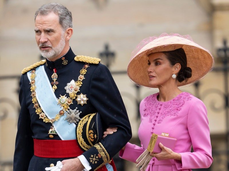 Image may contain: Felipe VI of Spain, Queen Letizia of Spain, Person, Adult, Clothing, Hat, Accessories, Wallet, and Jewelry