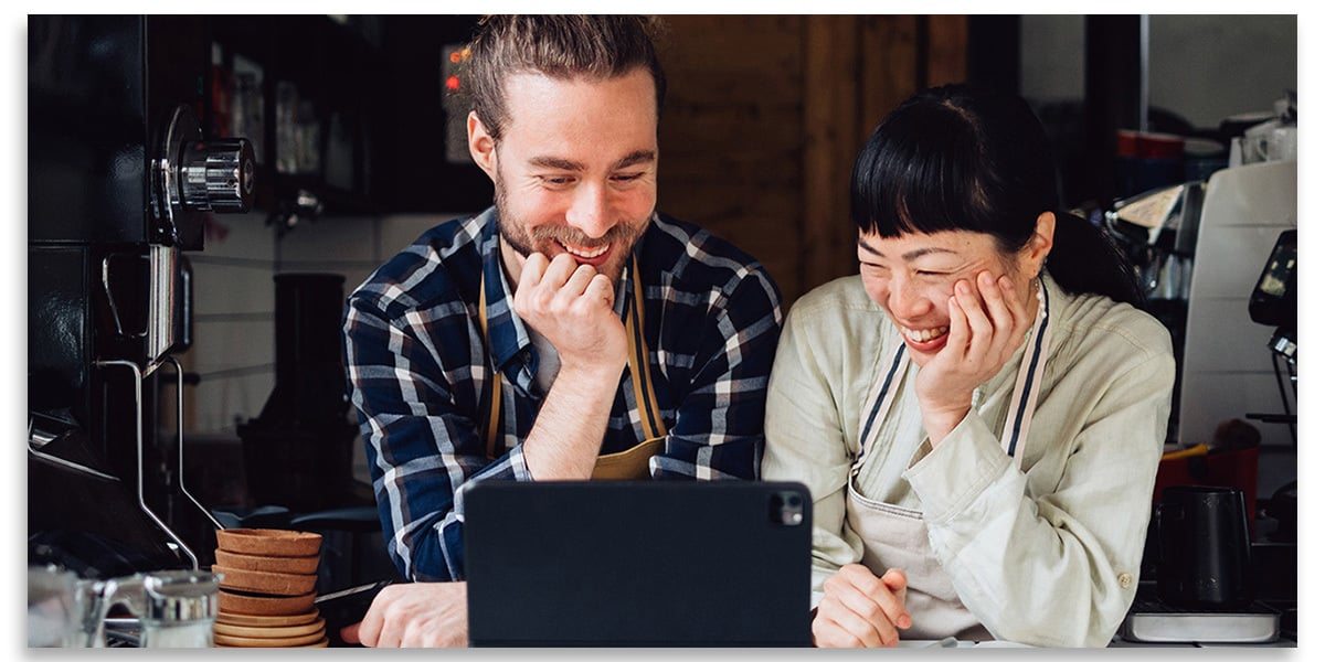 Hands holding a credit card and using a laptop.