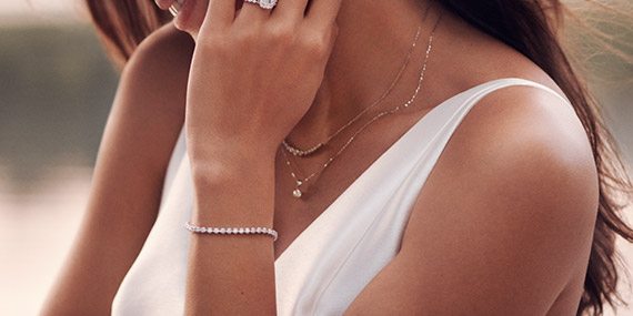 Smiling woman wearing a Neil Lane diamond engagement ring