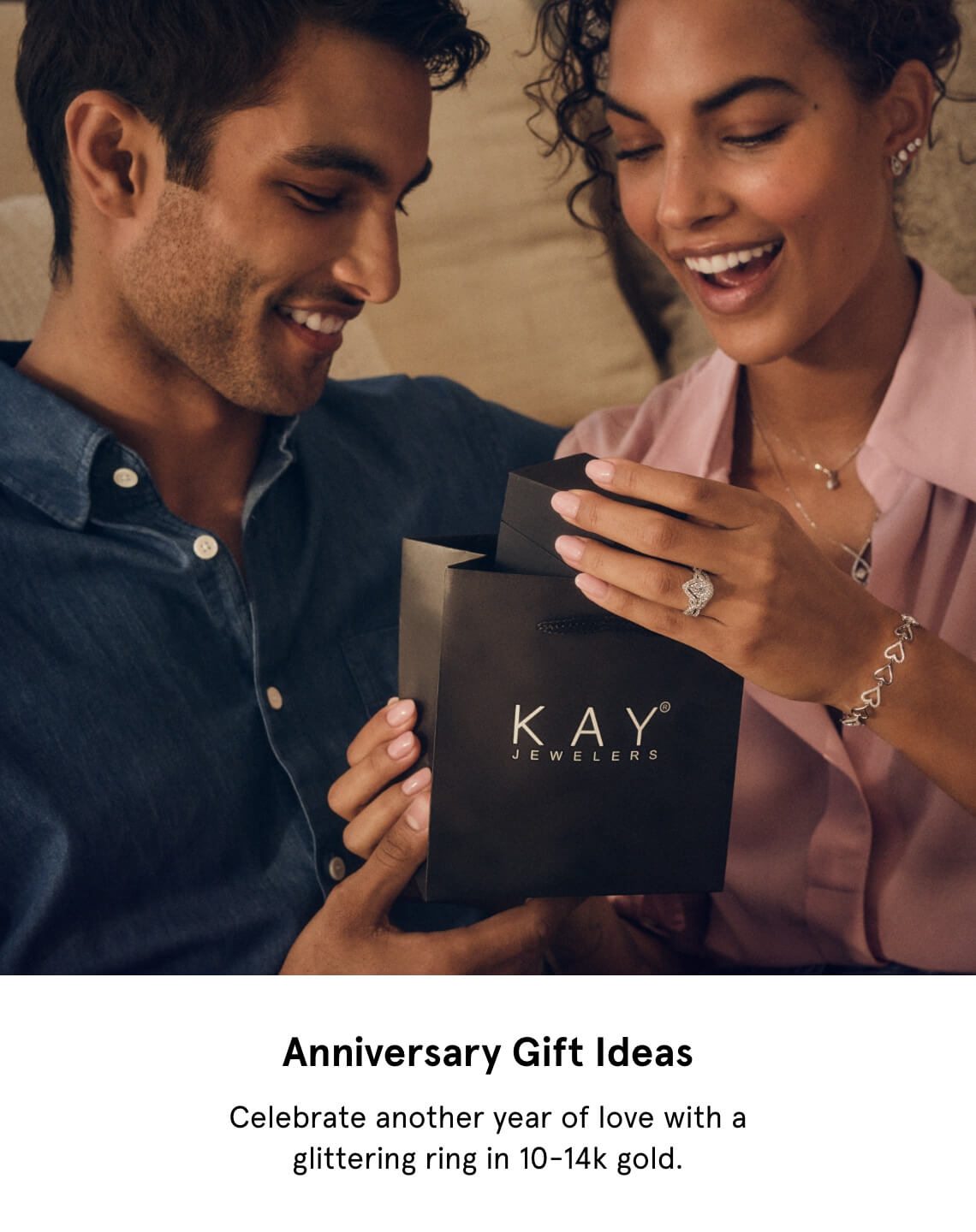 Anniversary Gift Ideas | Image of man holding a KAY gift bag as he gives it to smiling woman