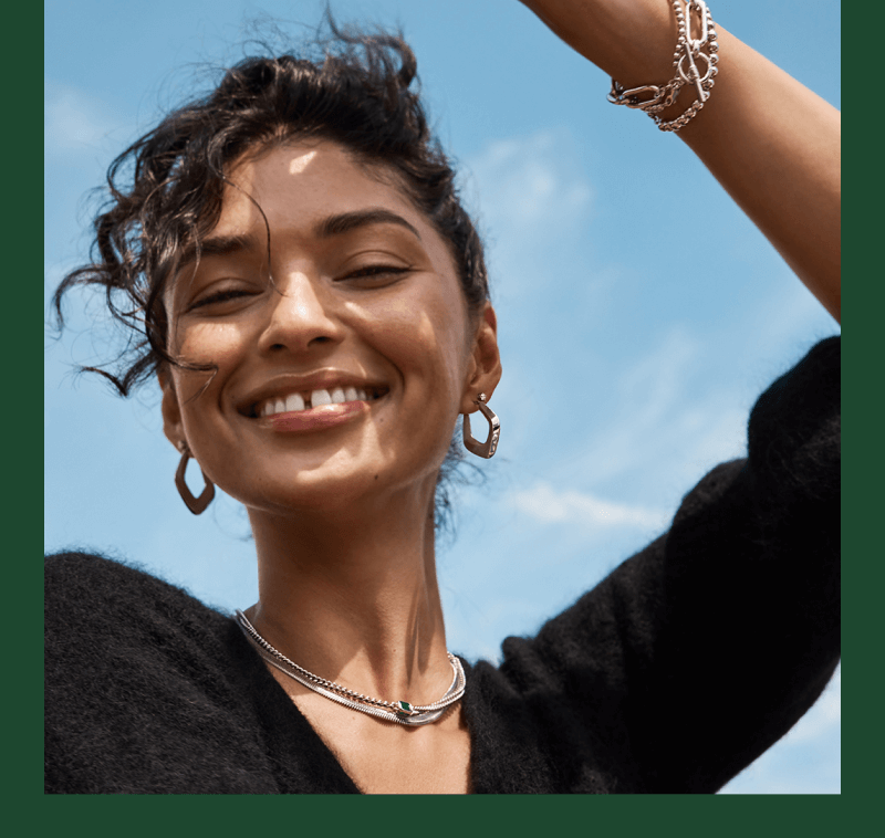 A woman happily poses, showcasing her new beautiful Diamond Jewelry - Necklaces, Earrings and Bracelets.