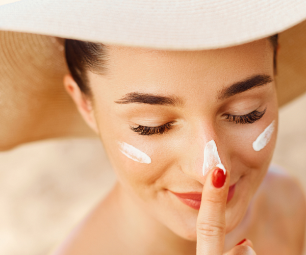 Woman applying sunscreen to her nose