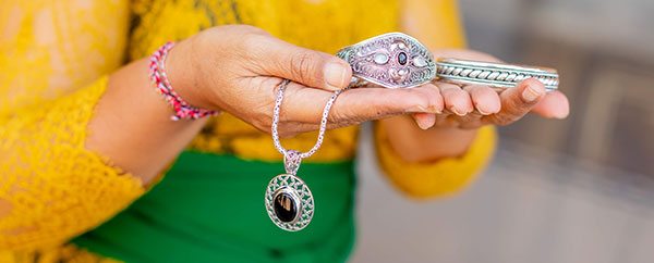 Picture of artisan holding jewelry