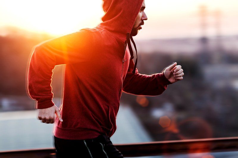 Man running outdoors in a red sweatshirt