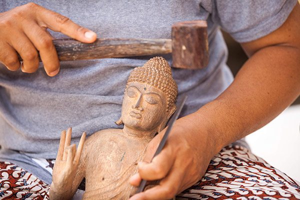 Wayan Rendah carves a sculpture