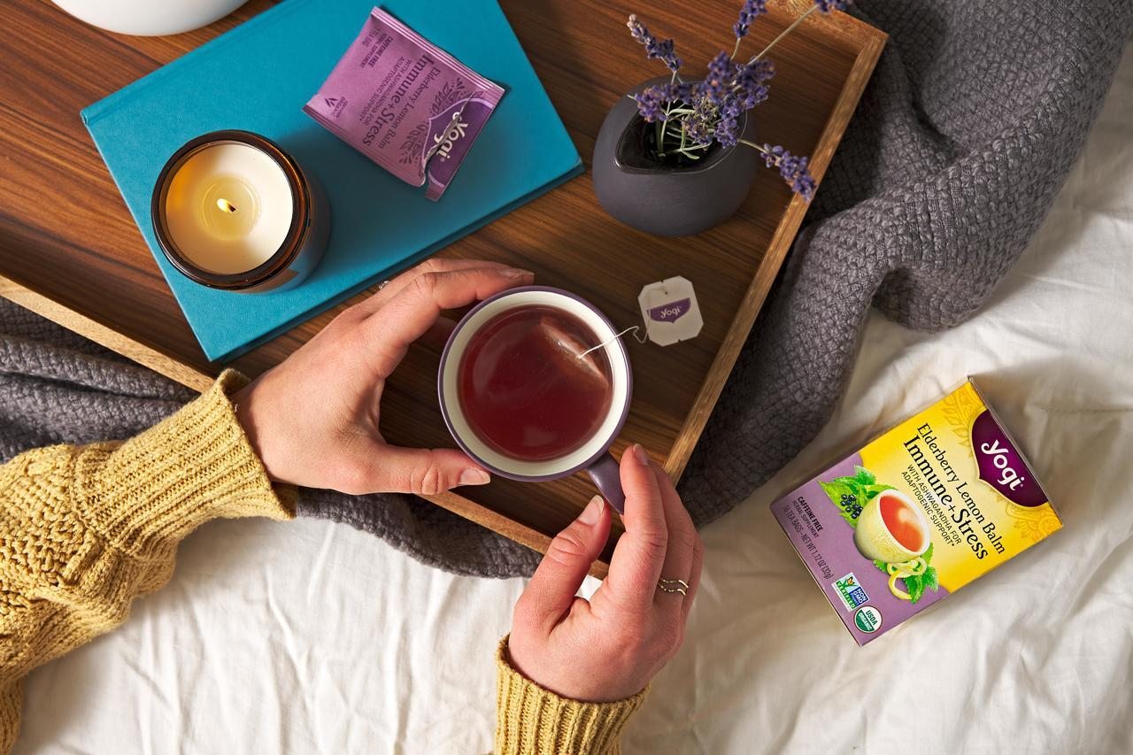 Woman's hands holding cup of Yogi Elderberry Lemon Balm Immune + Stress tea