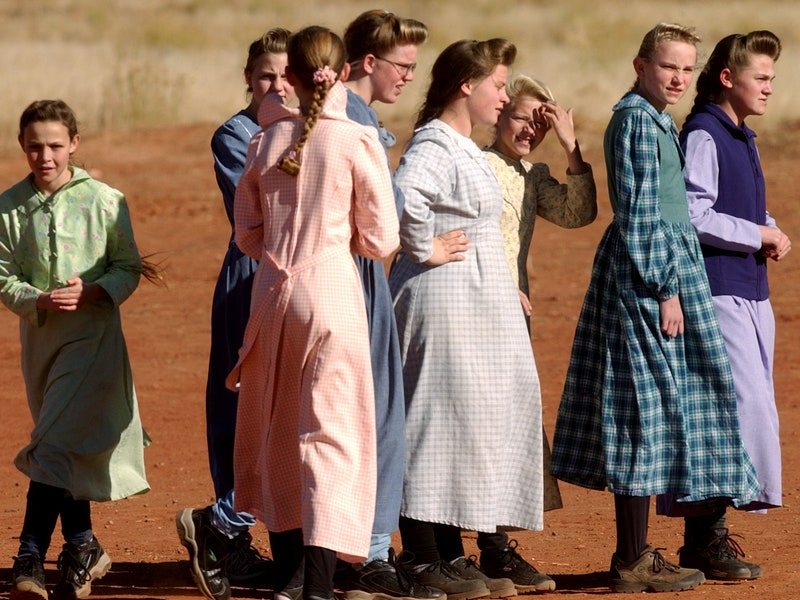 01_22_04_COLORADO CITY, ARIZONA-School children dressed in the traditional garb of the FLDS play after school in an open field. The men wear trousers and shirts buttoned up to the very top of the collar. Women must wear their long hair back, tied on top of their head and braided down the back. They also wear handmade laced tops and long prairie skirts or long dresses with trousers underneath to hide as much skin as possible. FUNDAMENTALIST CHURCH OF JESUS CHRIST OF THE LATTER DAY SAINTS . PHOTO BY HELEN H. RICHARDSON (Photo By Helen H. Richardson/The Denver Post via Getty Images)