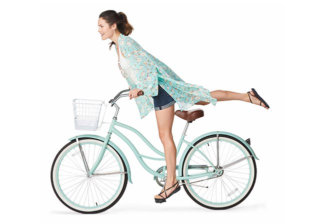 Model riding a bicycle in Crocs Isabella Gladiator Sandals