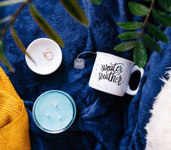 Cozy sweater with mug and candles