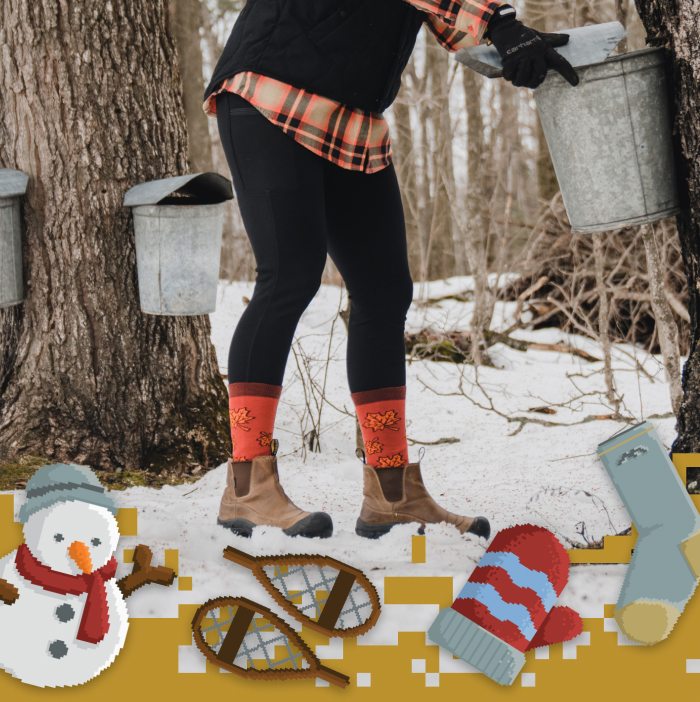 Shop Socks - a Vermonter check on maple sap buckets in the snowy woods, wearing orange Darn Tough socks with maple leaves.