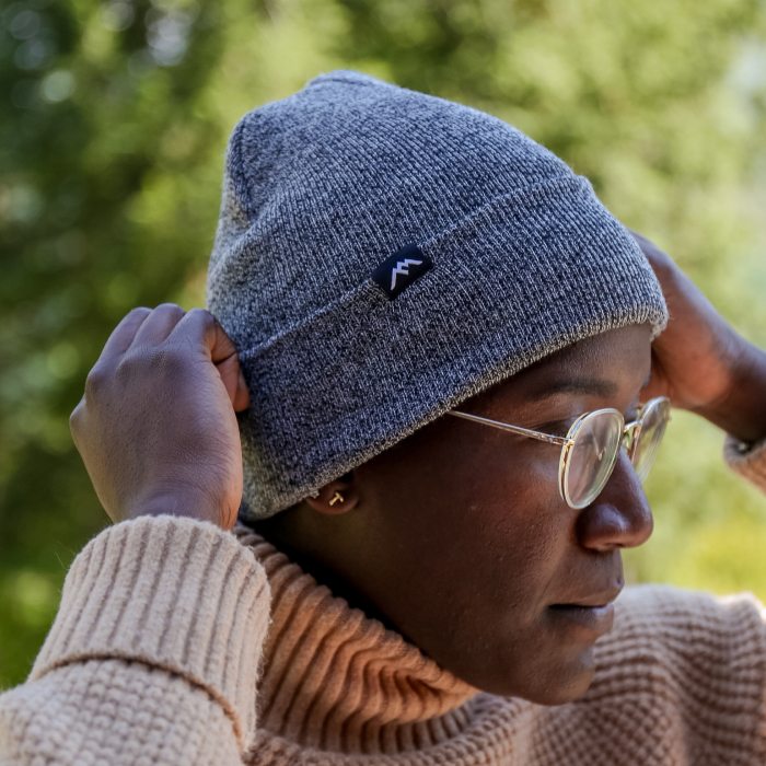 Get a free Beanie - a woman adjusts a soft grey beanie on her head